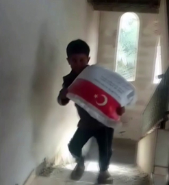 Kendi ağırlığı kadar un çuvalını taşıyan Filistinli çocuğun sevinci